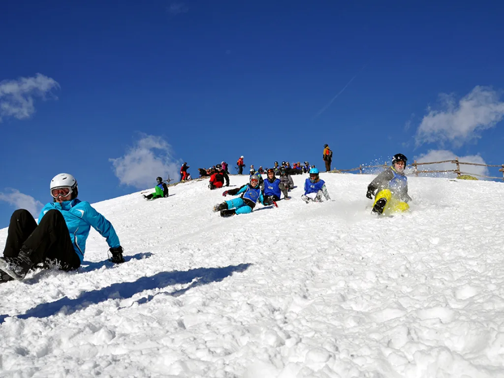 Jugendliche machen Pause auf der Kuppe unter blauem Himmel.